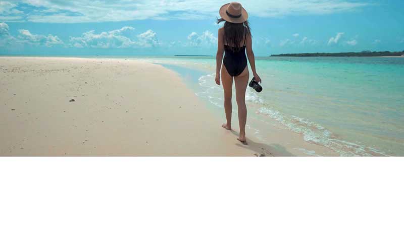 full size intro video with a woman on vacation walking on a beach